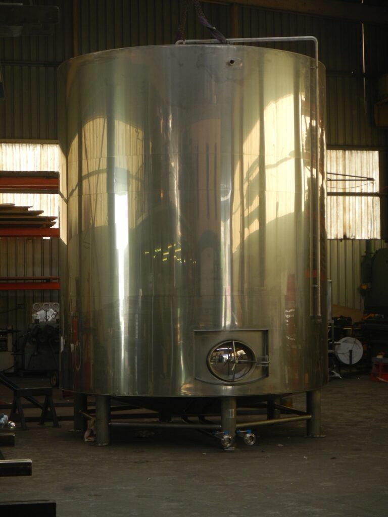 29,700 litre insulated stainless steel milk silo with side entry manway, standing on legs
